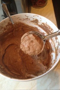 Using an ice cream scoop to portion the cupcake batter.