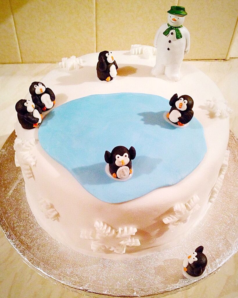 Meet our penguins, the theme for a fondant covered Christmas cake.