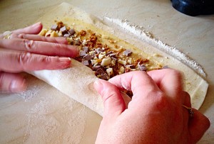 Use both hands to ensure the pastry is evenly rolled.