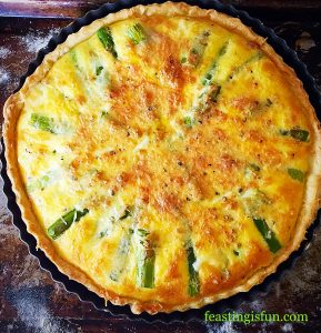 Baked quiche on a baking tray.