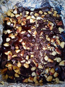 Sprinkle the chopped nuts and chocolate evenly over the top of the brownie batter.
