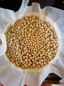 Place parchment paper onto the pastry and fill with baking beans or ceramic balls. These keep the pastry from collapsing during the blind baking.