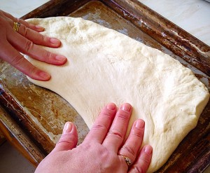 Keep patting with your hands, very gently stretching the dough as you do...