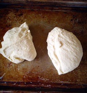 Using a dough cutter or knife, divide the dough in half.