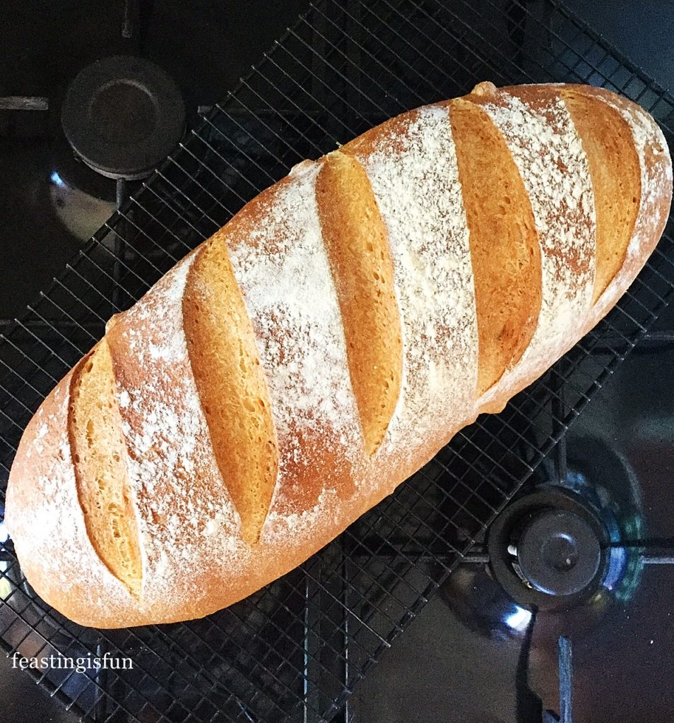 Freshly baked crusty, organic, white bread on a cooling rack.