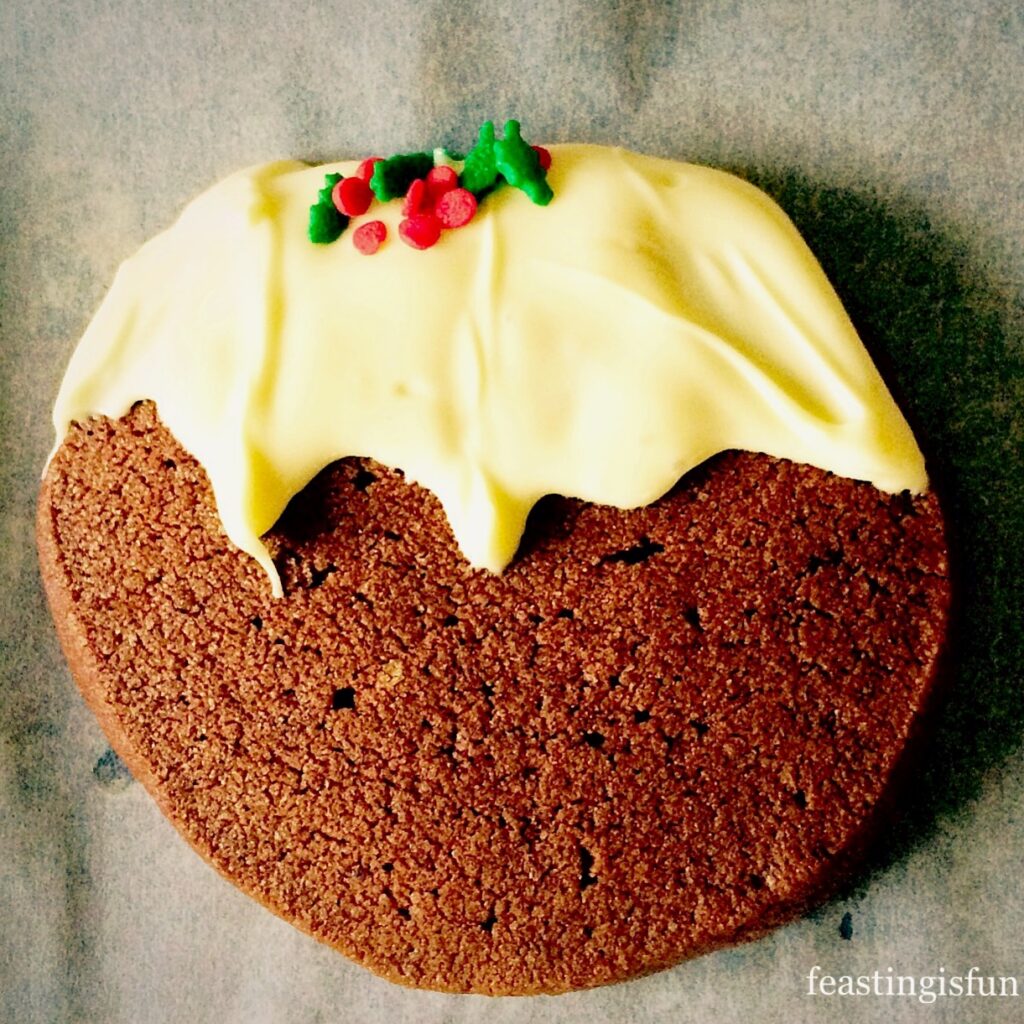Chocolate Christmas Pudding Cookies decorated with white chocolate and sprinkles.