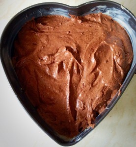 Spoon the chocolate cake batter into the heart tin.