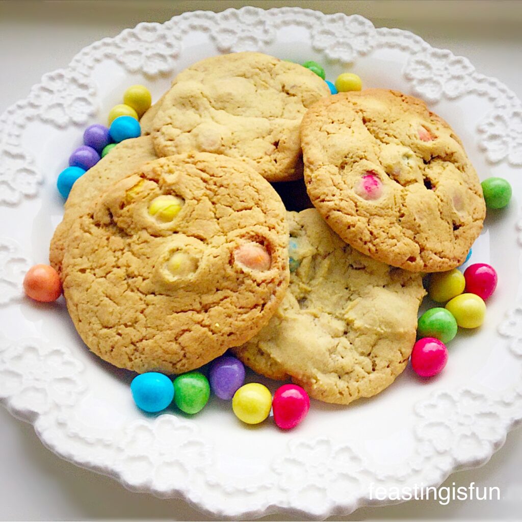 Large, Easter mini egg cookies piled up on a white platter.