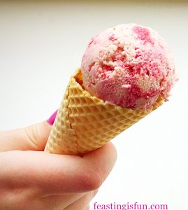 Strawberry ripple ice Cream in a cone.