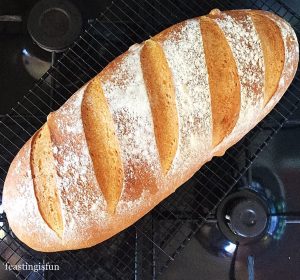 Family sized white bloomer loaf cooling on a rack.