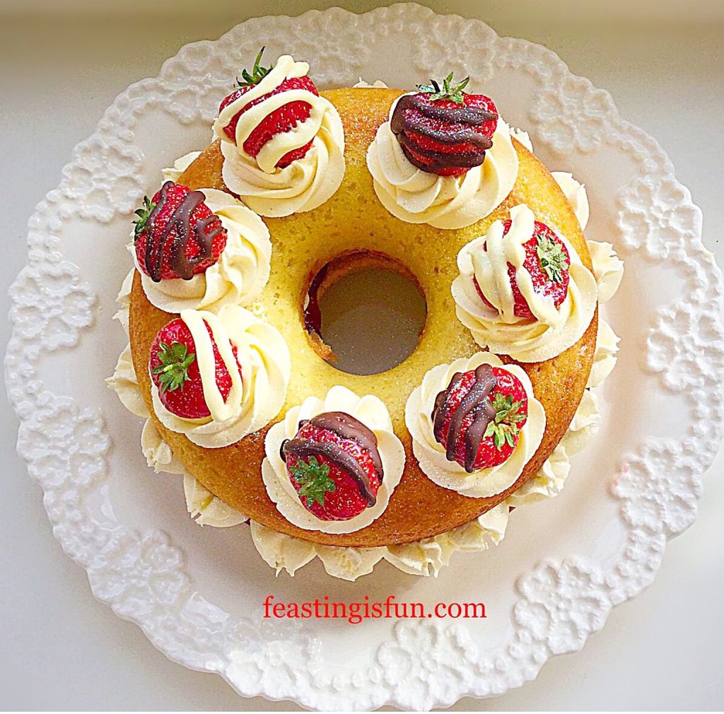 Large, baked doughnut filled with whipped cream and decorated with chocolate strawberries.