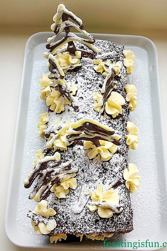 Cherry and whipped cream filled chocolate sponge roll. Topped with chocolate trees and a dusting of icing sugar snow.