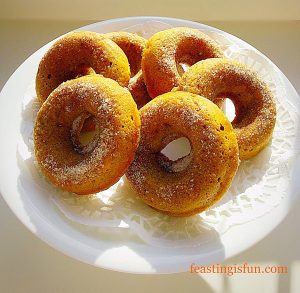 Baked pumpkin spiced doughnuts displayed on a cake stand.