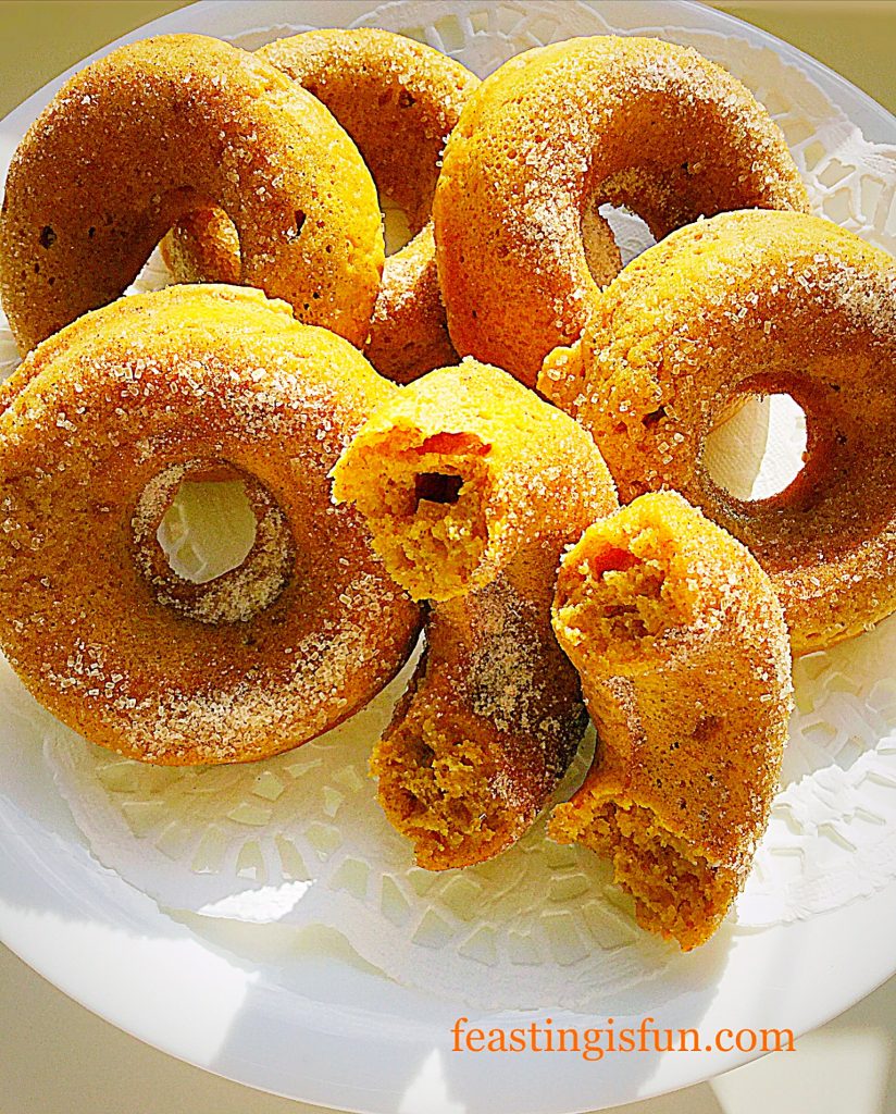 Pumpkin spiced donuts broken in half to show light and airy texture.