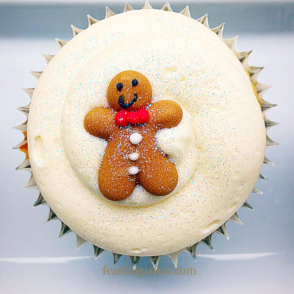 Single, individual spiced sponge with miniature festive person on to of the icing.