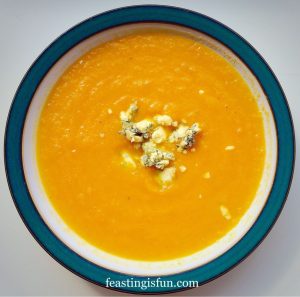 Carrot Soup in a bowl with crumbled Stilton cheese on top.
