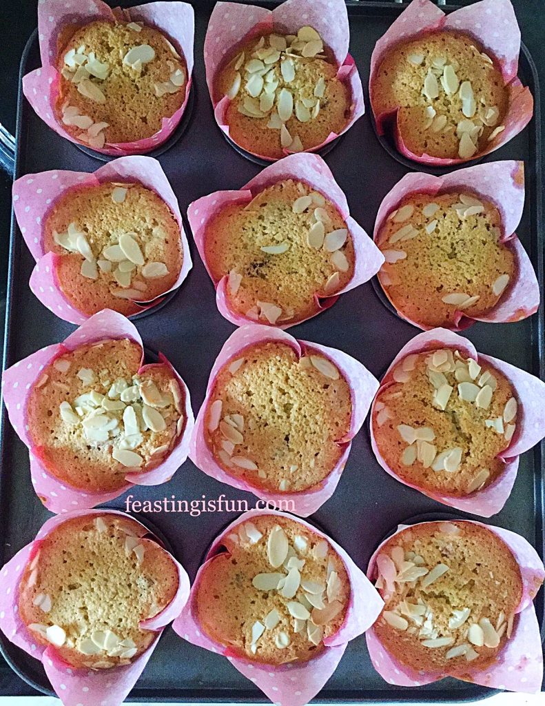 Muffins in tulip wrappers cooling in the tin.