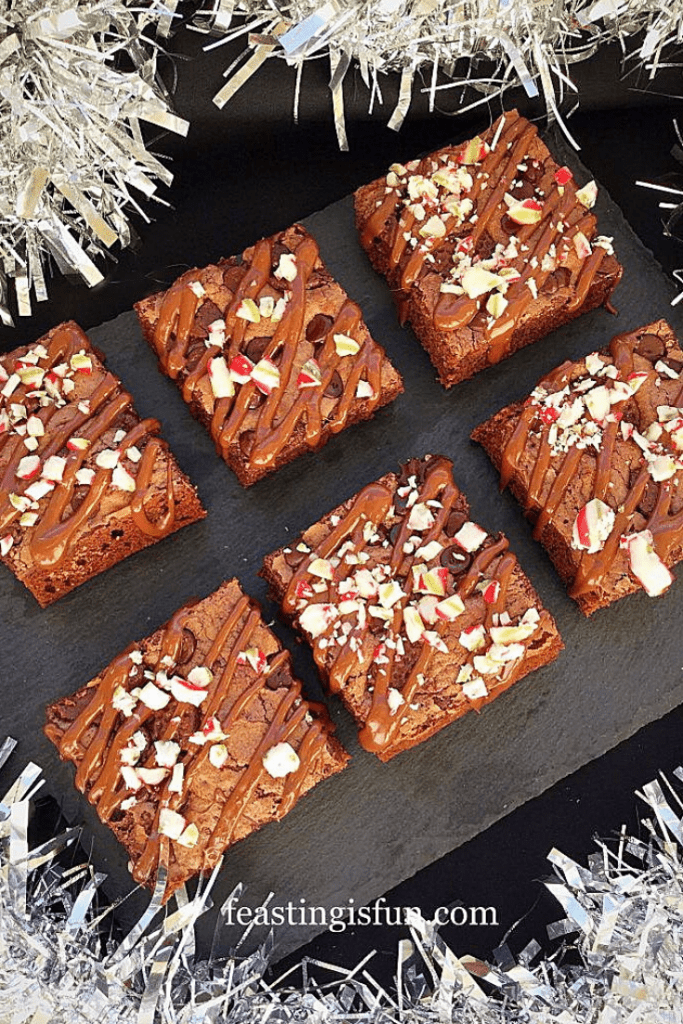Festive mint chocolate baked squares on a slate platter surrounded with silver tinsel