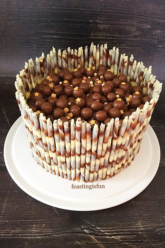 Baked swirled sponge covered in ganache and surround with edible pencils.