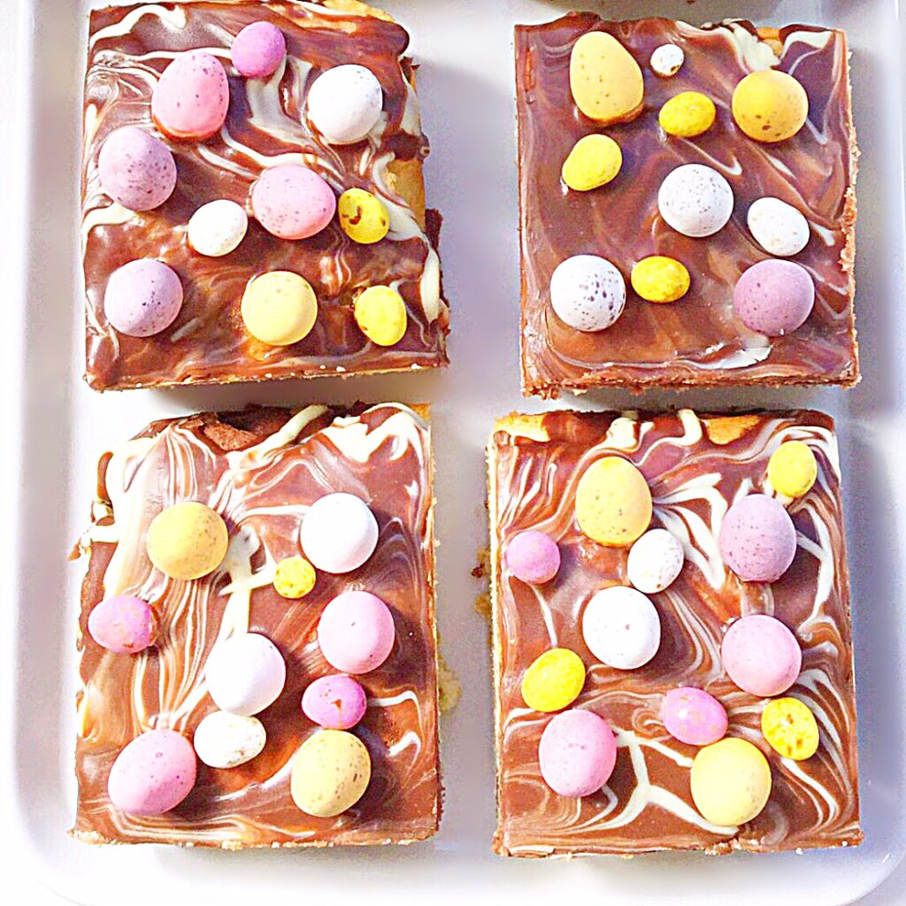 Easter traybake cake decorated with mini eggs.