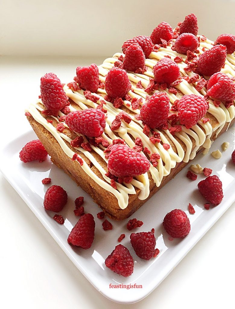 Fresh and freeze dried raspberries decorate this raspberry white chocolate loaf cake