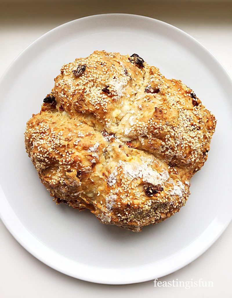 Uncut feta and sun dried tomato bread topped with sesame seeds.