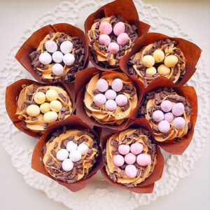 Cupcakes with chocolate piped nests filled with mini eggs.